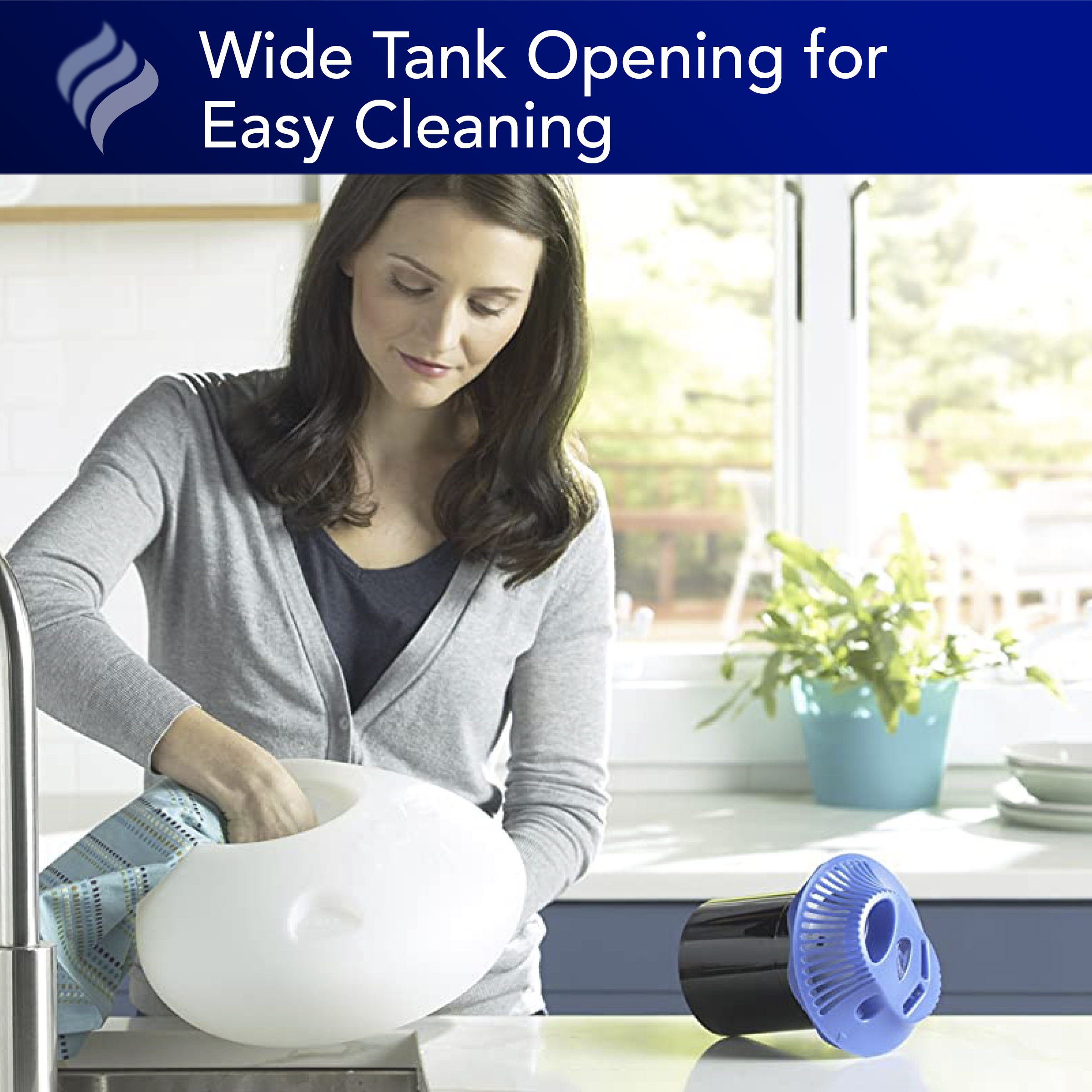 A lady cleaning the Vicks Warm mist vaporizer with a cleaning cloth over the sink through the wide opening tank